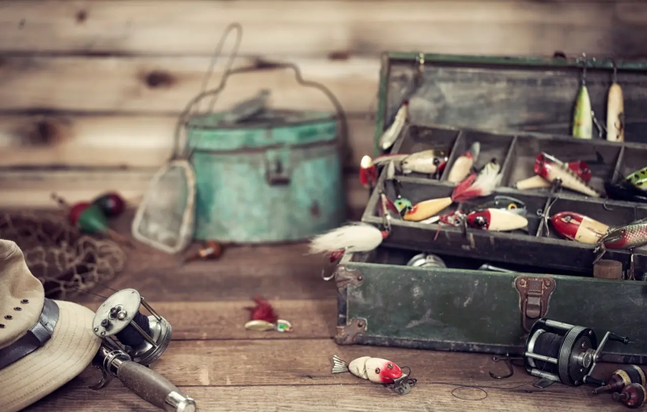 Fishing gear and tackle box on table.