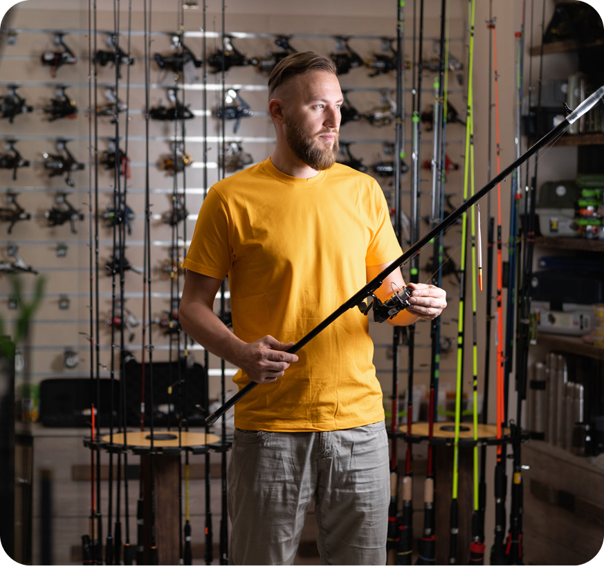 Man examining fishing rod in store.